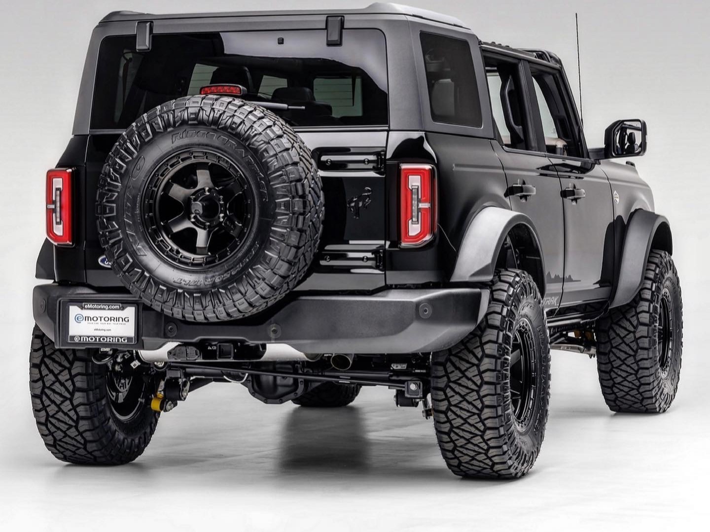 A blacked-out Ford Bronco with an eMotoring plate frame